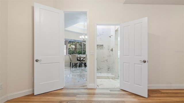 doorway featuring light hardwood / wood-style floors and a chandelier