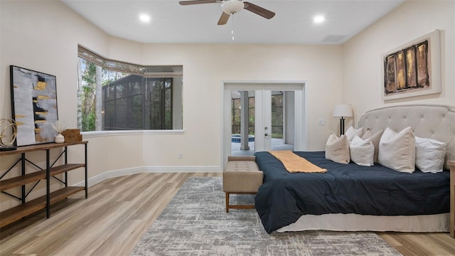 bedroom with multiple windows, hardwood / wood-style flooring, access to exterior, ceiling fan, and french doors