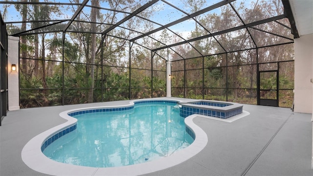 view of swimming pool featuring an in ground hot tub, a patio, and glass enclosure