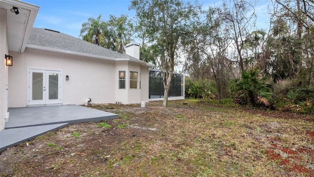 view of yard featuring french doors, a patio, and glass enclosure