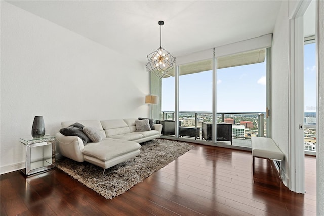 living room with an inviting chandelier, a healthy amount of sunlight, and hardwood / wood-style floors