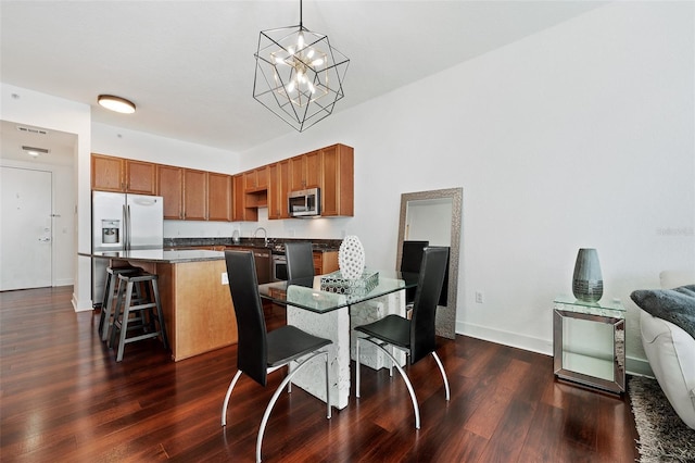 dining area featuring an inviting chandelier, sink, and dark wood-type flooring