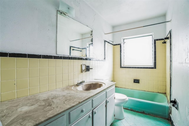 full bathroom featuring tile walls, tiled shower / bath combo, vanity, tile patterned flooring, and toilet