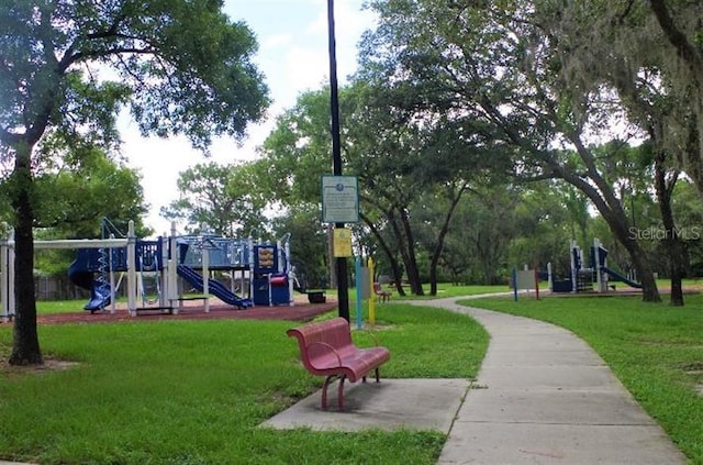 surrounding community featuring a playground and a lawn