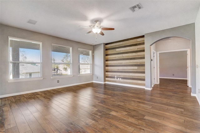 unfurnished room featuring ceiling fan and dark wood-type flooring