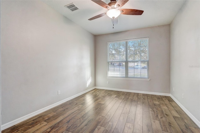 empty room featuring dark wood-type flooring and ceiling fan