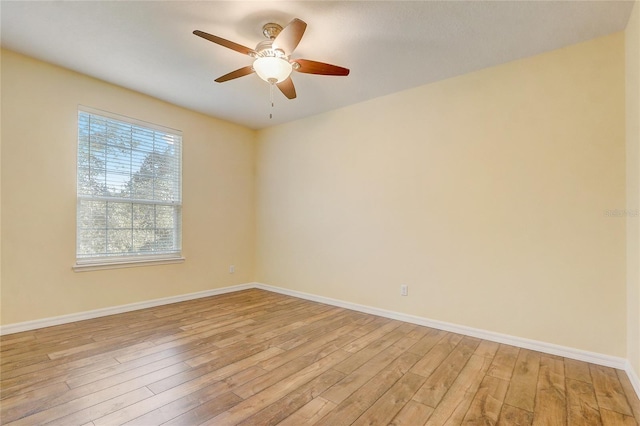 empty room with ceiling fan and light hardwood / wood-style flooring