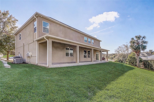 rear view of property with a patio area, central air condition unit, and a yard