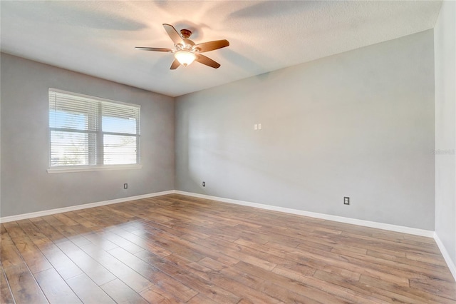 empty room with light hardwood / wood-style floors, ceiling fan, and a textured ceiling