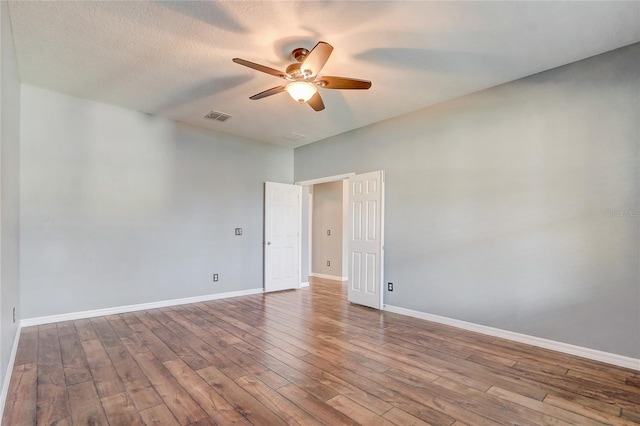 unfurnished room featuring ceiling fan, wood-type flooring, and a textured ceiling