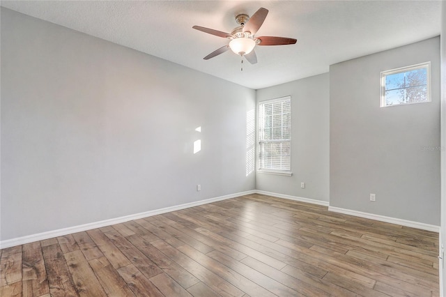 empty room with ceiling fan, light hardwood / wood-style floors, and a wealth of natural light