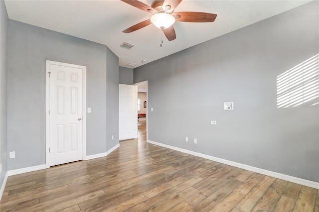 empty room with ceiling fan and wood-type flooring