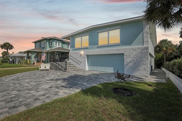 view of front of home featuring a garage, a yard, and covered porch