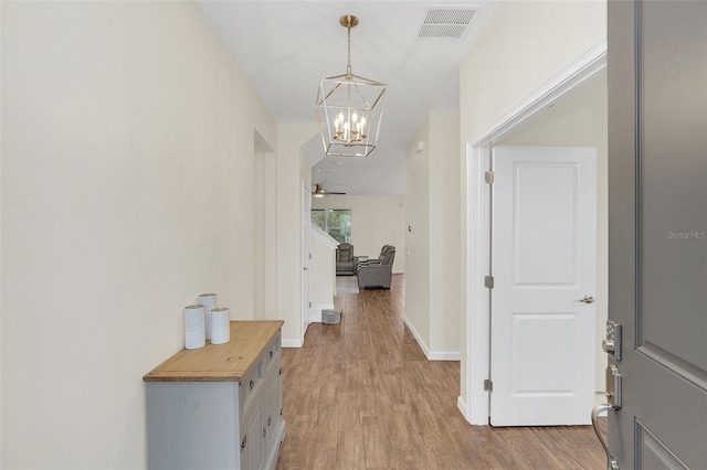 hallway with a chandelier and light hardwood / wood-style flooring