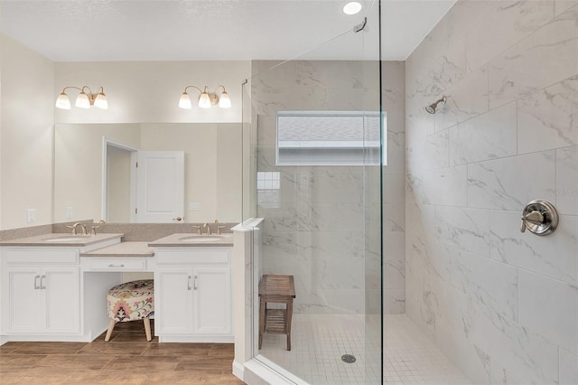 bathroom featuring a tile shower and vanity