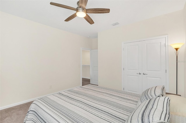 bedroom with light colored carpet, a closet, and ceiling fan