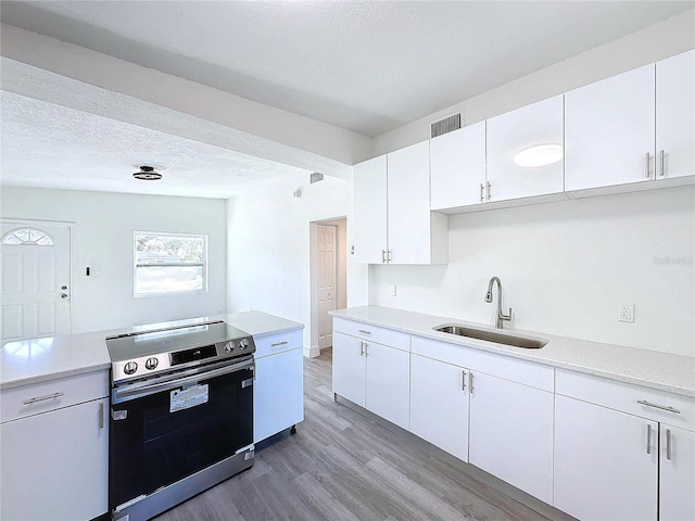 kitchen with white cabinets, sink, and stainless steel range with electric cooktop