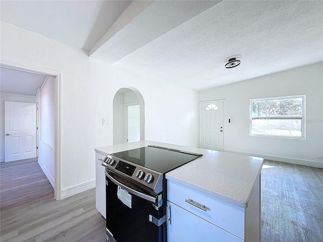 kitchen with white cabinetry, electric range, light stone countertops, a textured ceiling, and light hardwood / wood-style flooring