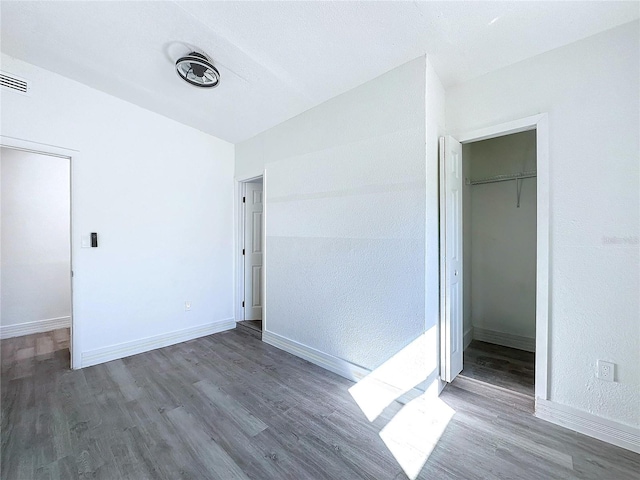 unfurnished bedroom featuring wood-type flooring and a closet