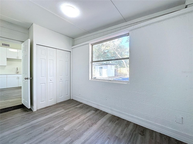 unfurnished bedroom featuring sink, light hardwood / wood-style flooring, and a closet