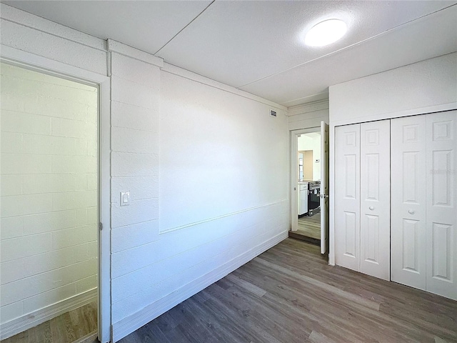 unfurnished bedroom featuring dark hardwood / wood-style floors and a closet