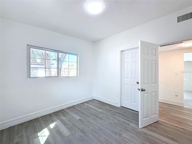 unfurnished bedroom with hardwood / wood-style floors and a textured ceiling