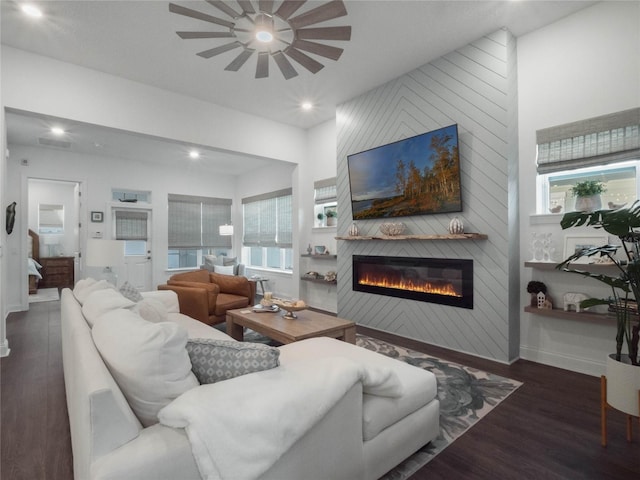 living room with a large fireplace and dark wood-type flooring