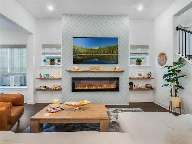 living room featuring a large fireplace and dark hardwood / wood-style flooring