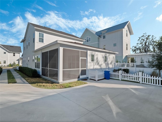 rear view of house featuring a sunroom