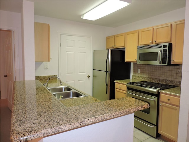 kitchen with stainless steel appliances, kitchen peninsula, sink, and light brown cabinets