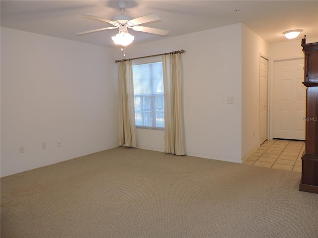 carpeted spare room featuring ceiling fan