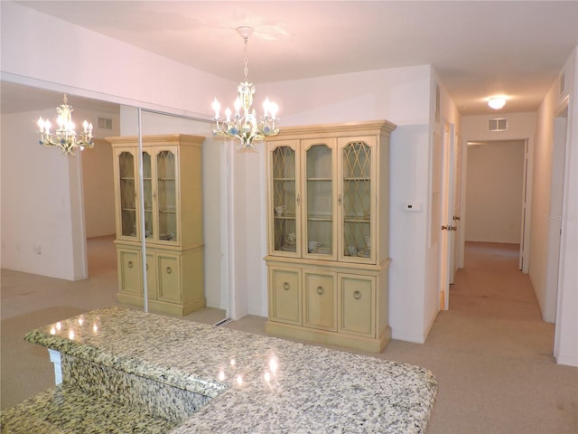 unfurnished dining area with an inviting chandelier and light colored carpet