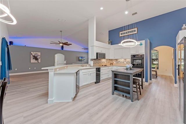 kitchen featuring white cabinetry, pendant lighting, backsplash, and light wood-type flooring