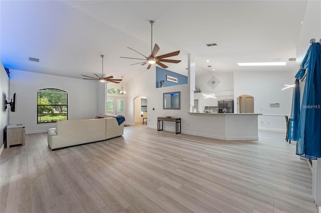 living room with ceiling fan, lofted ceiling, and light wood-type flooring