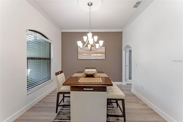 dining area with ornamental molding, light hardwood / wood-style floors, and a chandelier