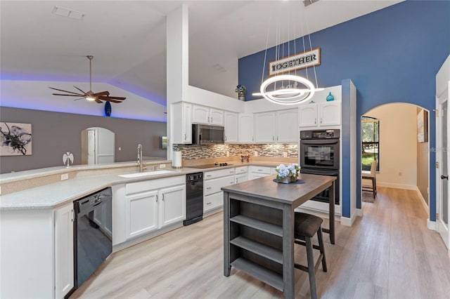 kitchen with decorative light fixtures, tasteful backsplash, sink, white cabinets, and black appliances