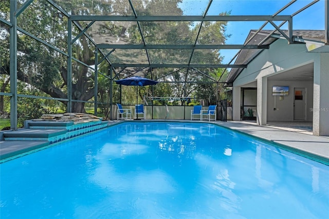 view of swimming pool featuring a patio and glass enclosure