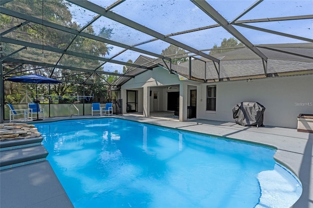 view of pool with a patio and glass enclosure