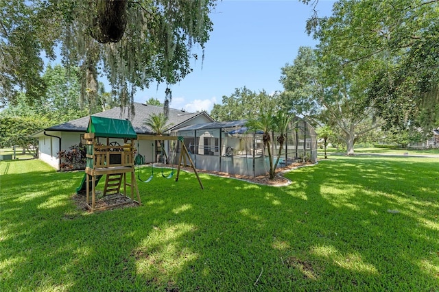 rear view of house with a yard, a lanai, and a playground