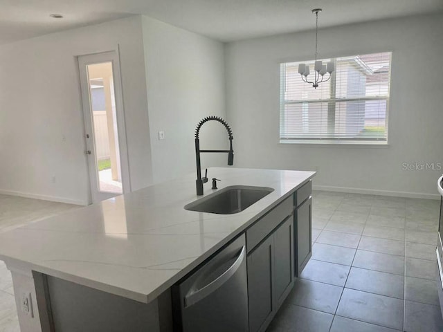 kitchen featuring sink, decorative light fixtures, a center island with sink, stainless steel dishwasher, and light stone countertops