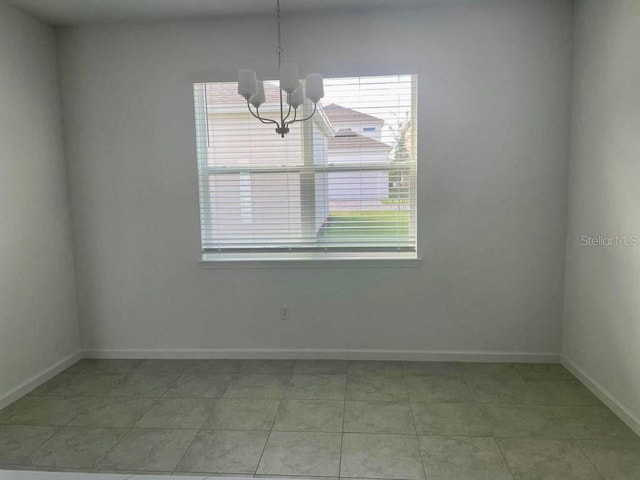 unfurnished room with a notable chandelier