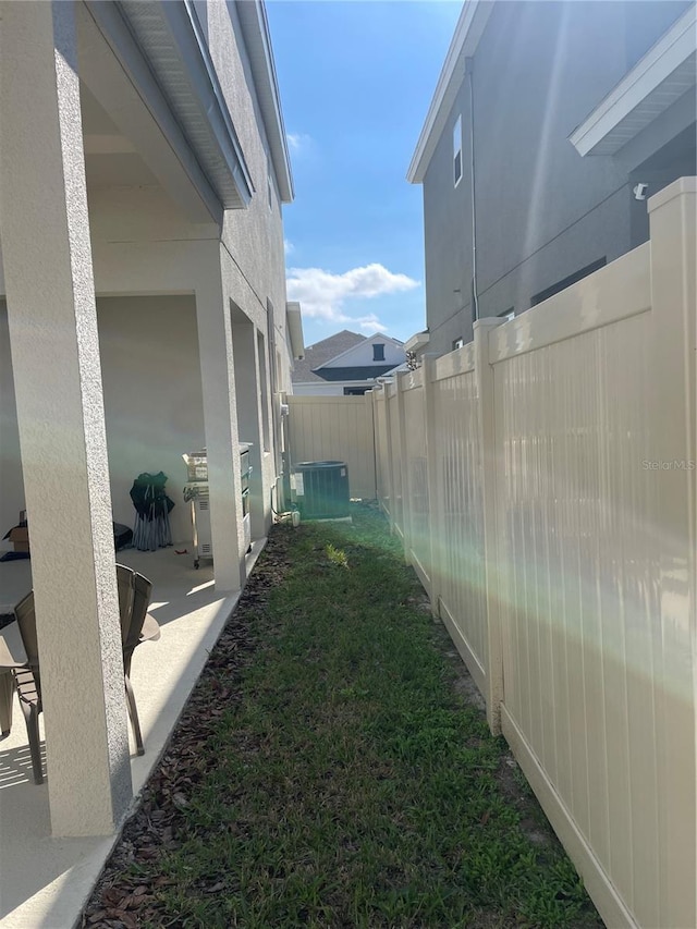 view of yard with central AC unit and a patio