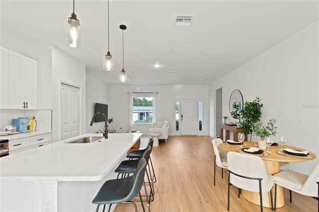 14735 SW 69th Court Rd, Ocala, FL 34473 - kitchen with a sink, light wood finished floors, white cabinets, light countertops, and recessed lighting