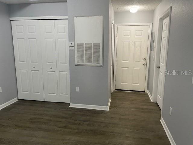 hallway featuring a textured ceiling and dark hardwood / wood-style flooring