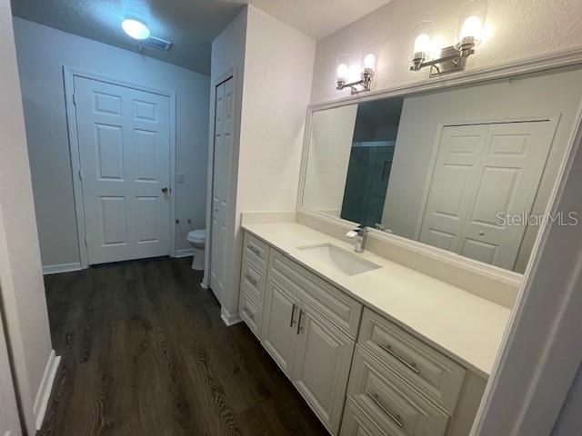 bathroom with vanity, toilet, and wood-type flooring