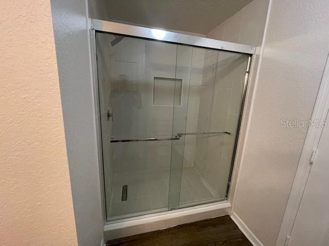 bathroom featuring hardwood / wood-style floors and an enclosed shower