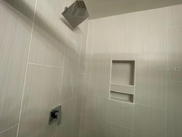 interior details featuring a tile shower