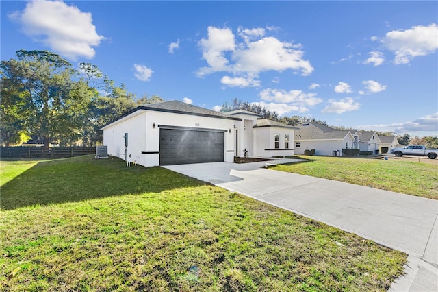 view of front of home featuring a garage, central AC unit, and a front yard