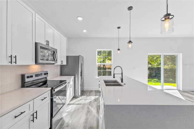 kitchen featuring white cabinetry, stainless steel appliances, sink, and pendant lighting