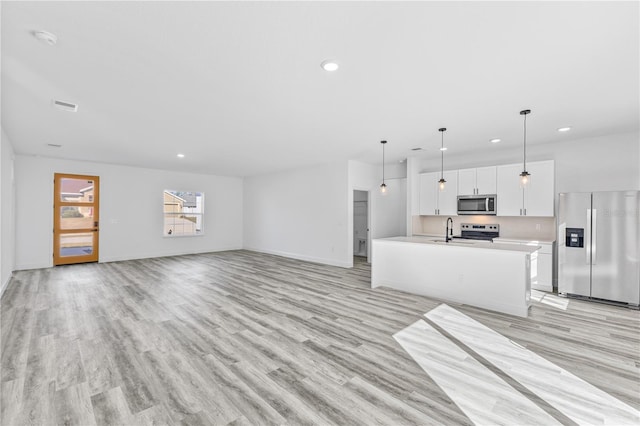 unfurnished living room with sink and light hardwood / wood-style flooring